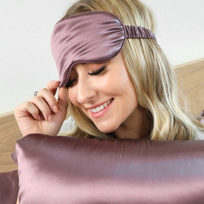 Side view of woman wearing soft pure mulberry silk Blissy eye mask in plum