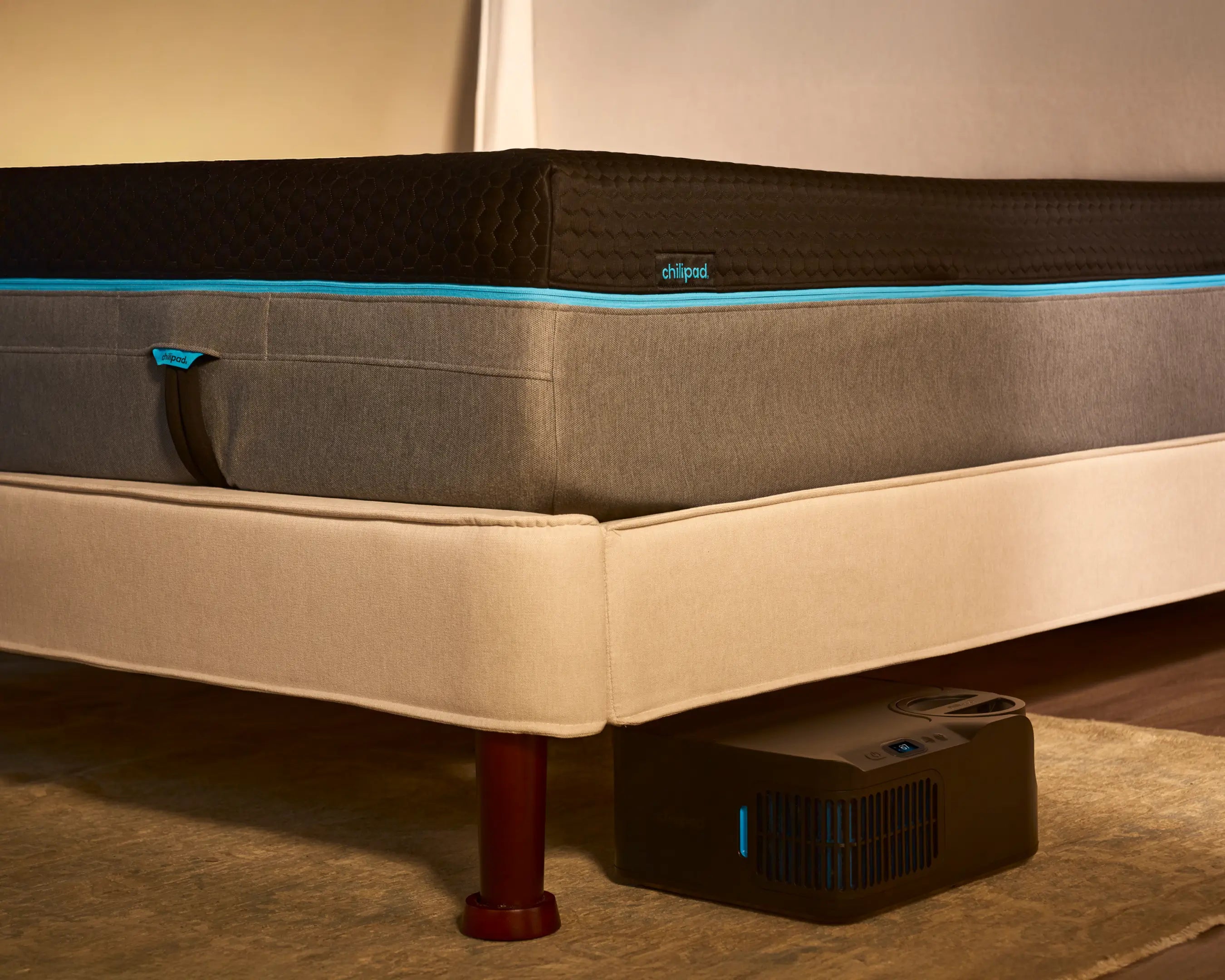 Mattress on a bed with Chilipad device on the floor.