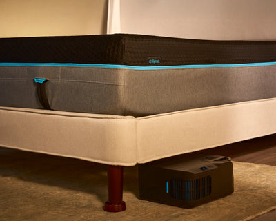 Mattress on a bed with Chilipad device on the floor.