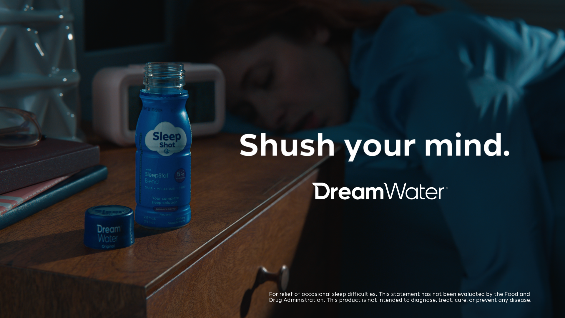 DreamWater bottle on a nightstand with text 'Shush your mind.' and 'DreamWater' branding.