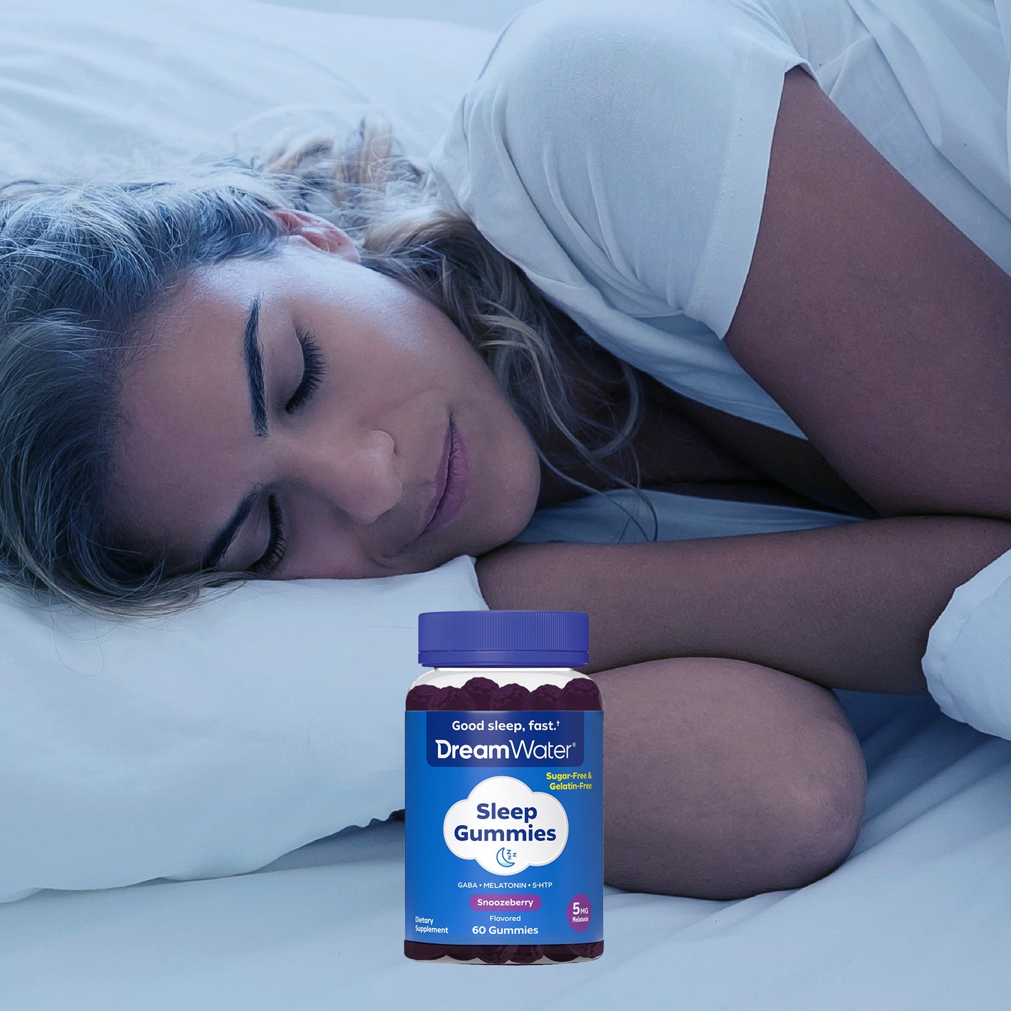 Woman lying in bed with a bottle of DreamWater Sleep Gummies on the bed.