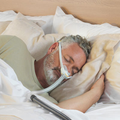 Man sleeping soundly on side wearing minimal-contact Fisher & Paykel Solo AutoFit mask