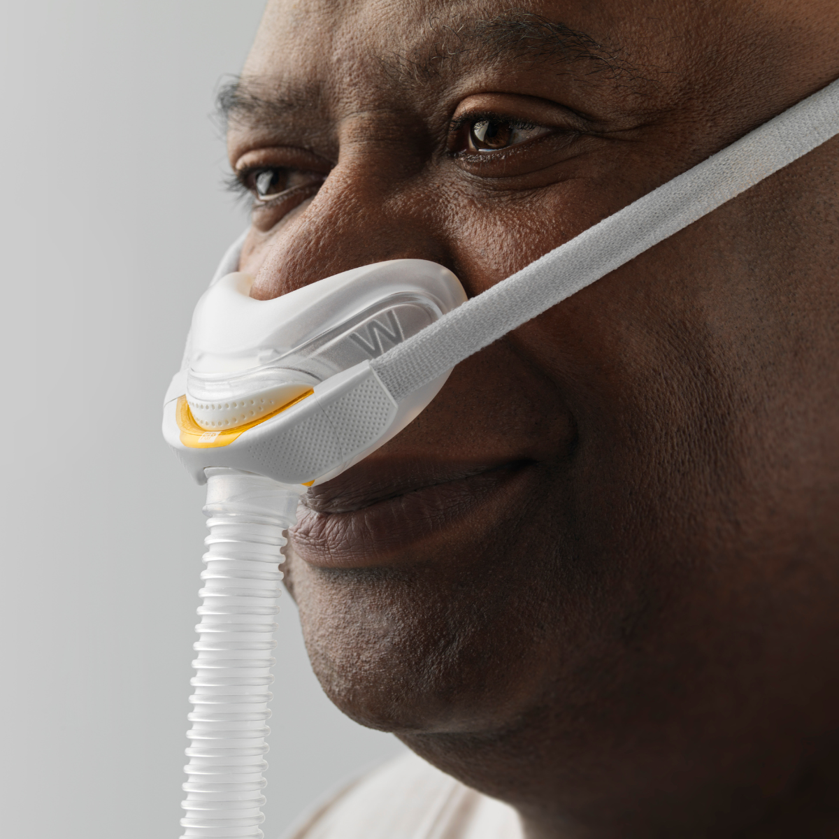 Male CPAP user resting comfortably while wearing Fisher & Paykel Solo AutoFit nasal mask