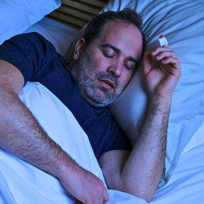 Man sleeping comfortably at home wearing wireless NightOwl sleep apnea test monitor