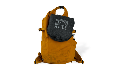 HEST Pro travel pillow packed inside rugged sleeve attached to hiking backpack