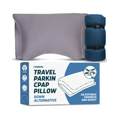 Lunderg Travel Parking CPAP Pillow shown with its packaging box. The product consists of a gray adjustable pillow and a dark blue rolled sleeping bag used as a support frame, displayed against a clean white background.