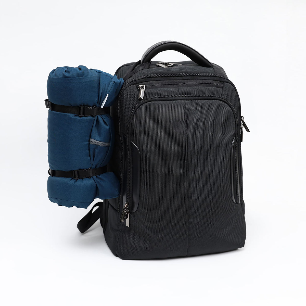 Black backpack with a blue sleeping bag attached on a white background