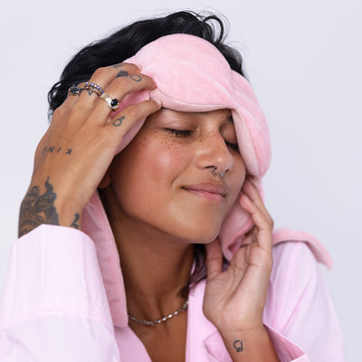 Nodpod weighted sleep mask in Blush Pink, in use for relaxing