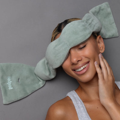 Woman reclining during meditation while using Nodpod weighted sleep mask