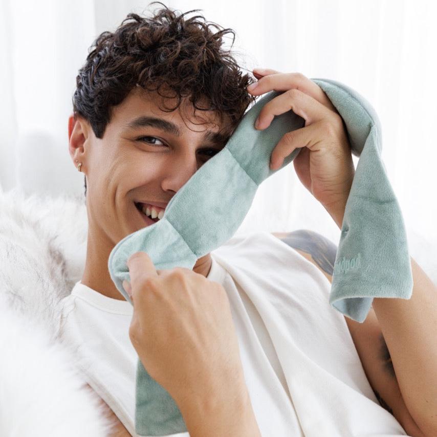 Model experiencing calming deep touch pressure with Nodpod weighted sleep mask