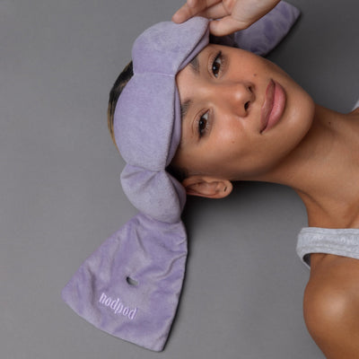 Woman resting comfortably with Nodpod wisteria sleep mask blocking unwanted light