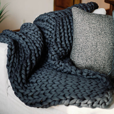 Nuzzie breathable chunky knit weighted blanket in charcoal gray laid flat