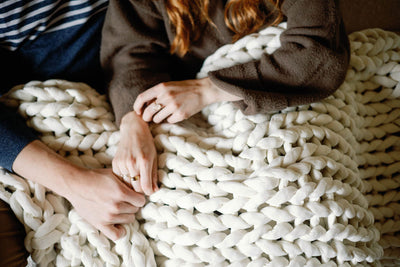 Nuzzie knit weighted blanket in Cream, in use for relaxing