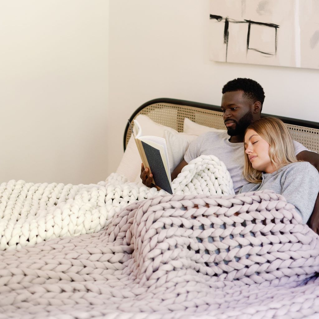 Nuzzie knit weighted blanket in Dusty Rose, on a person sleeping