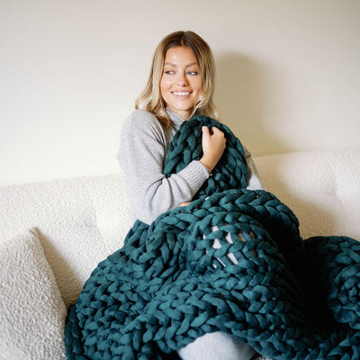 Nuzzie knit weighted blanket in Forest Green, in use for relaxing