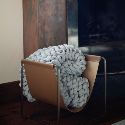 Nuzzie knit weighted blanket in Misty Grey, styled in a room