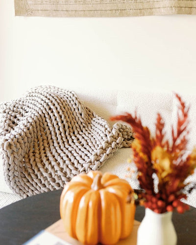 Nuzzie knit weighted blanket in Taupe, styled in a room