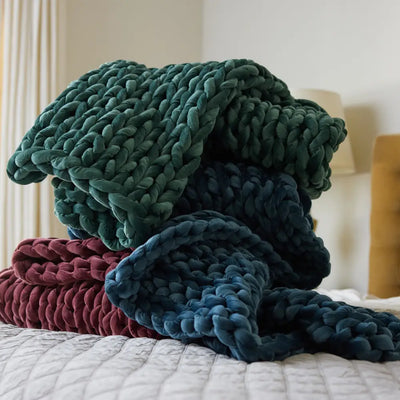 Nuzzie emerald green chunky velvet weighted blanket draped across modern bed