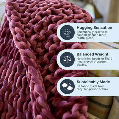 Person relaxing on couch beneath calming deep touch pressure of Nuzzie ruby velvet blanket