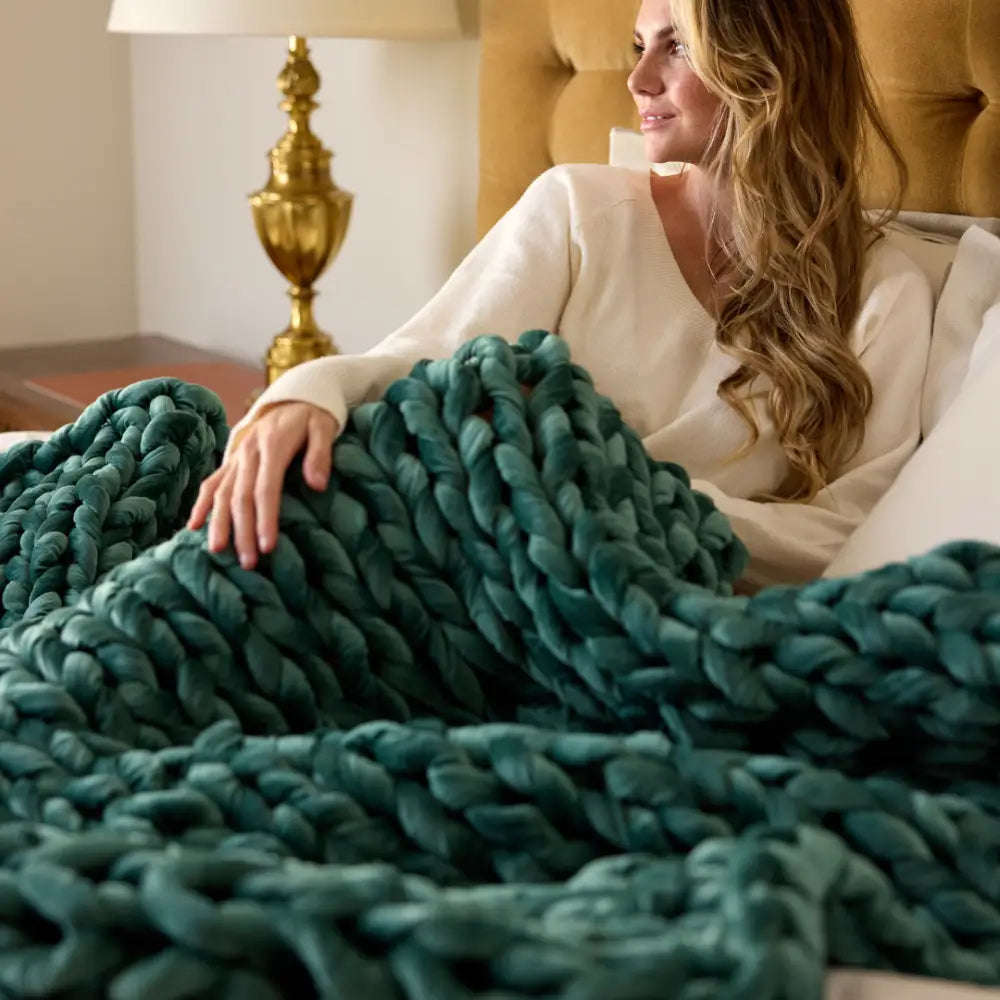 Person resting under soothing even weight of Nuzzie emerald velvet weighted blanket