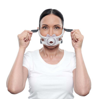 Female side sleeper wearing ResMed AirFit F40 ultra-compact full-face CPAP mask and headgear