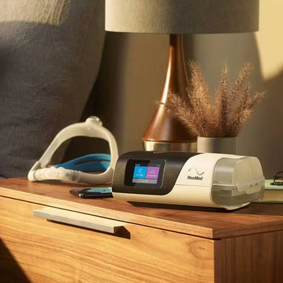 Resmed AirSense 11 AutoSet CPAP machine on a nightstand