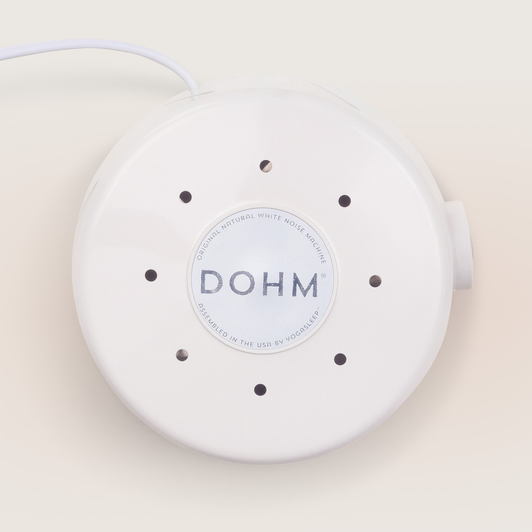 Side view of white Yogasleep Dohm Classic sound machine showing acoustic air louvers