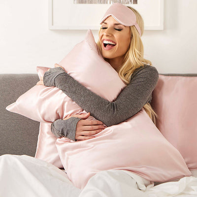 Woman resting comfortably while wearing Blissy pure mulberry silk sleep mask in pink