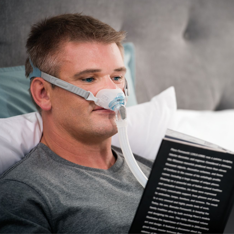 A man reading with a Fisher & Paykel Brevida AirPillow Mask Cushion