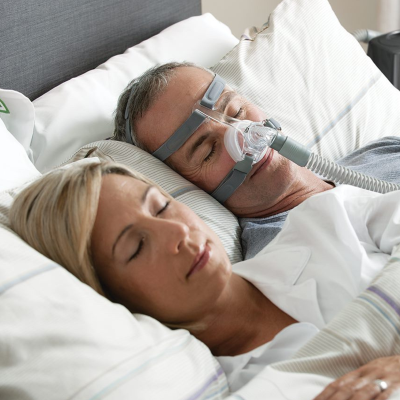 Couple sleeping and man wearing Fisher & Paykel Nasal CPAP Mask