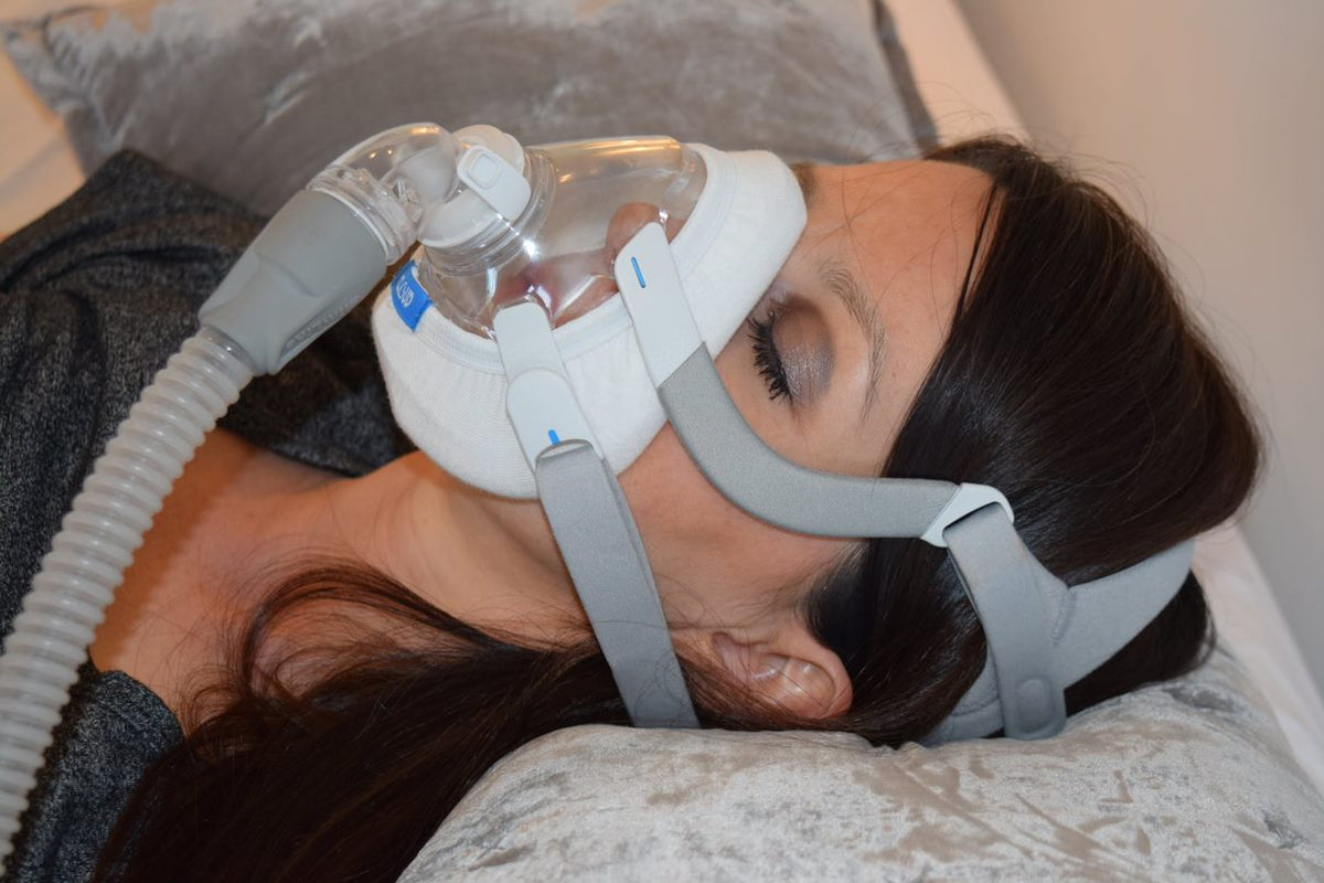 Person sleeping on side wearing full-face CPAP mask with CLOUD bamboo fabric mask liner